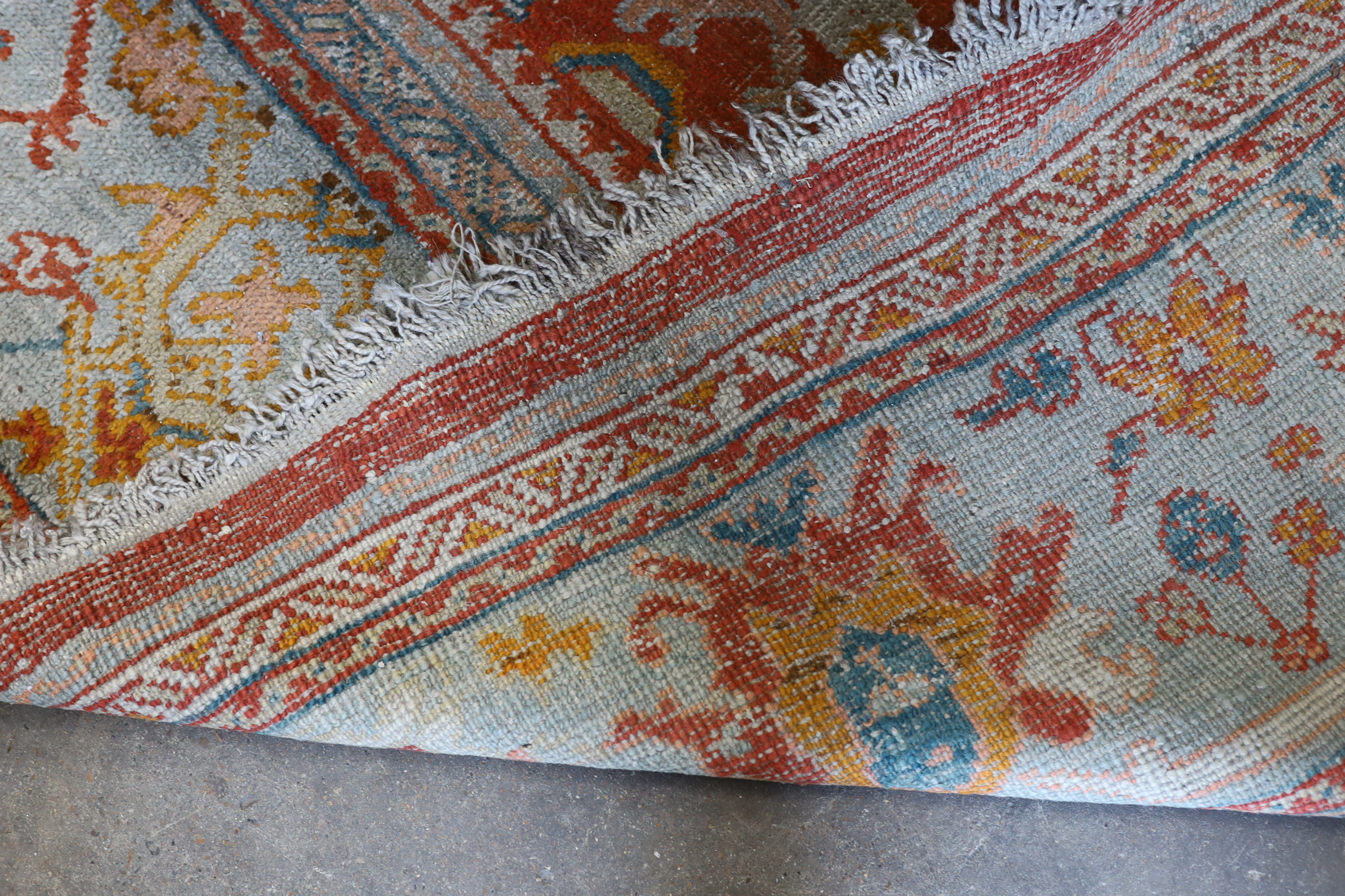 An Afghan red ground carpet, 395 x 310cm